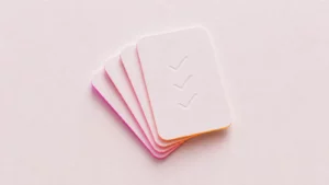 A fanned stack of paper cards with debossed tick marks